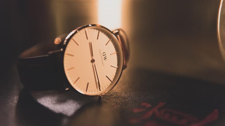 Un orologio da polso appoggiato su una scrivania scura